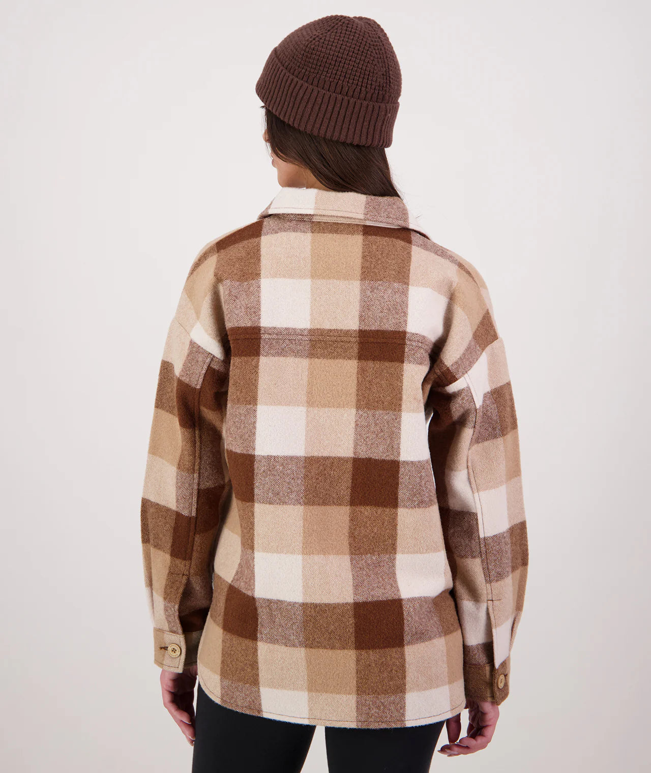 Person wearing a brown and beige checkered shirt with a plain background