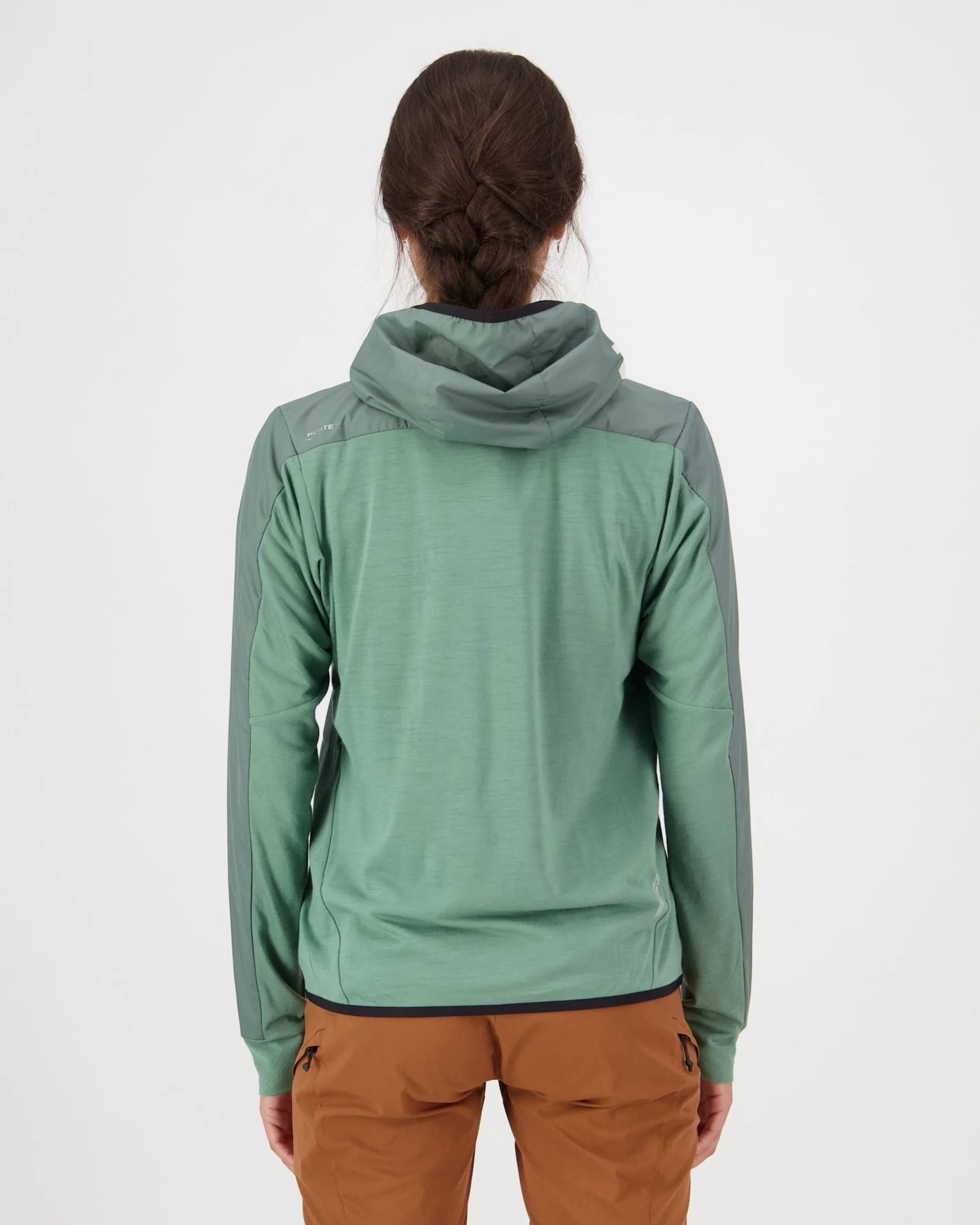 Person wearing a green hooded jacket and brown pants on a white background