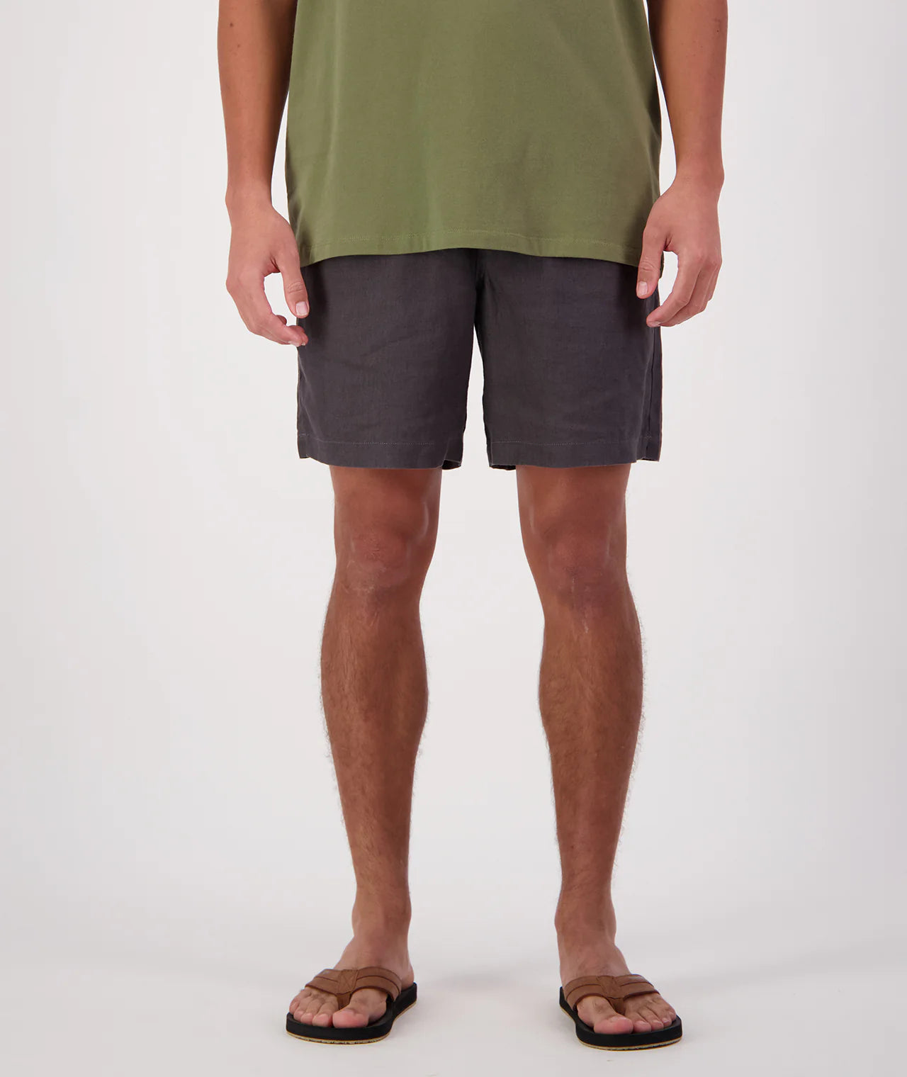 Person wearing a green shirt and dark shorts on a white background