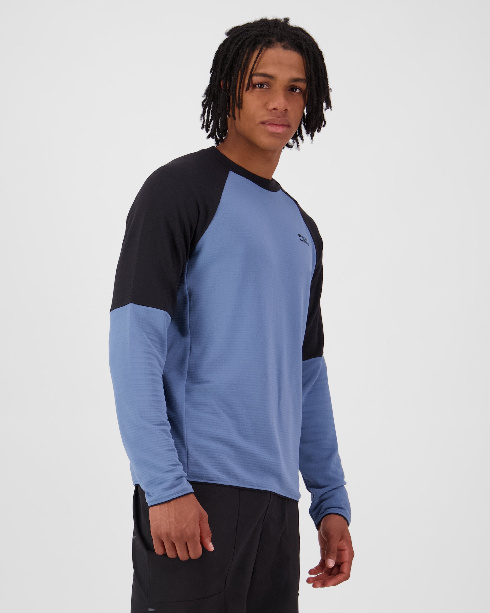 Person wearing a black and blue long-sleeve shirt on a white background