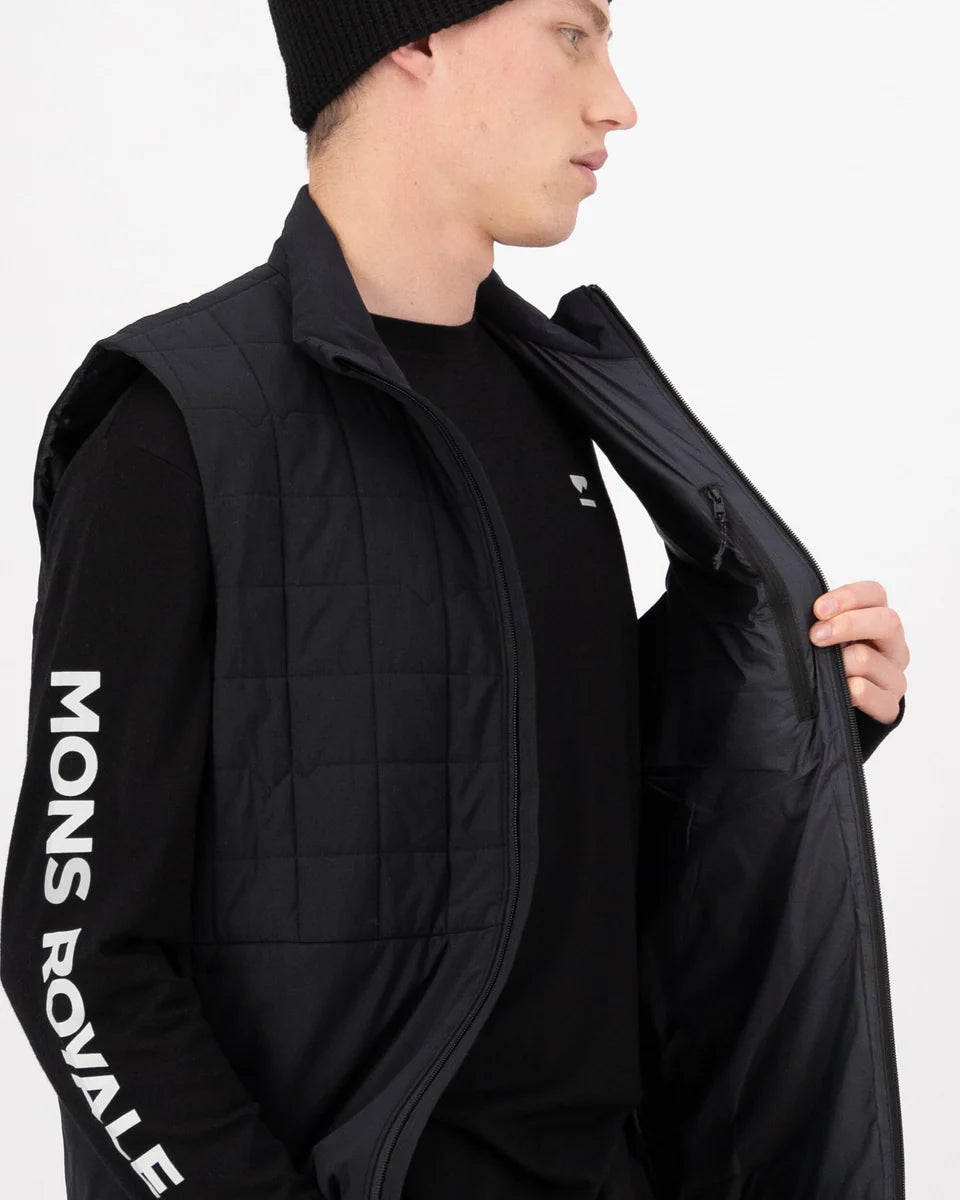 Person wearing a black puffer vest with 'Mons Royale' branding on a white background