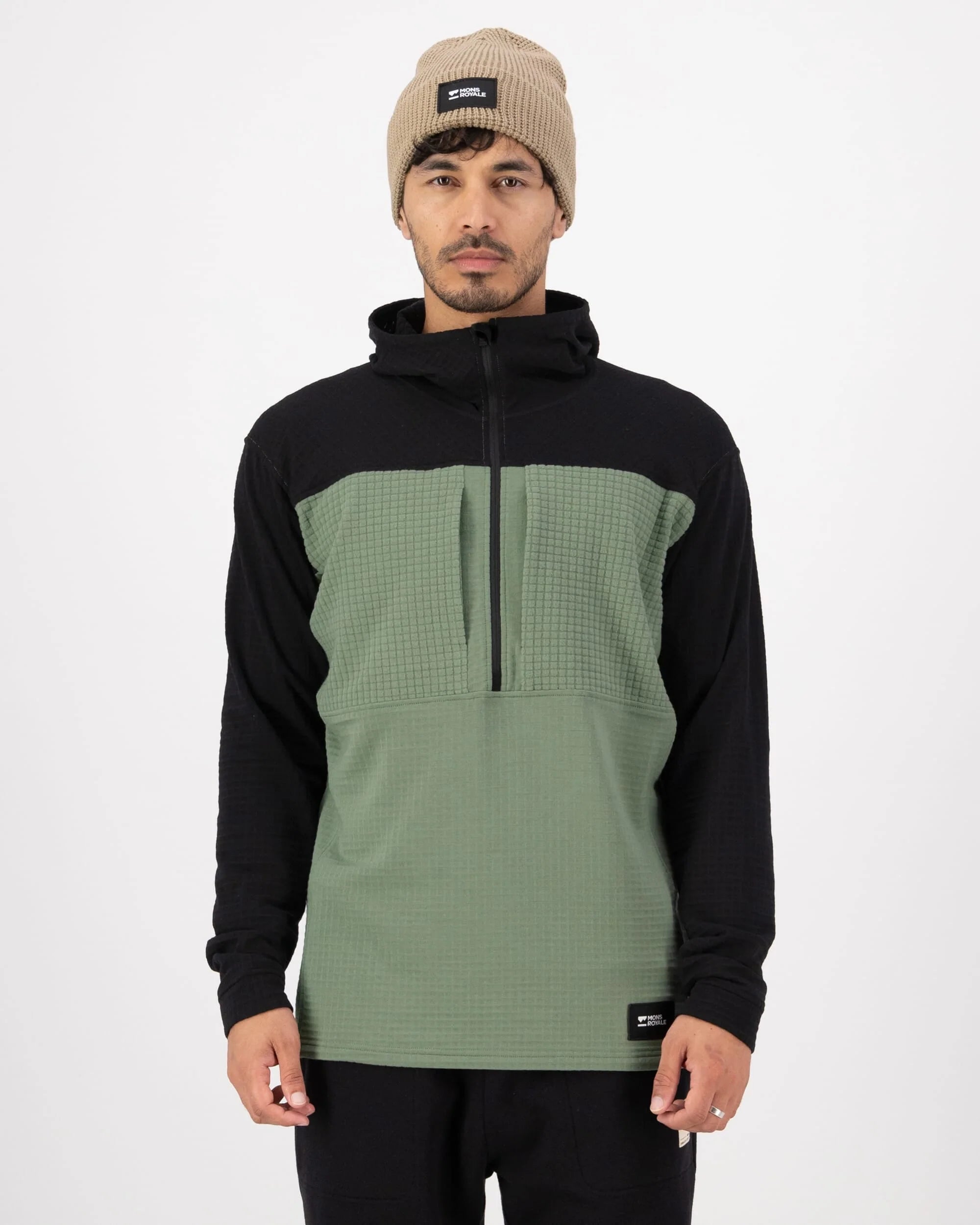 Man wearing a black and green hoodie with a beanie on a white background