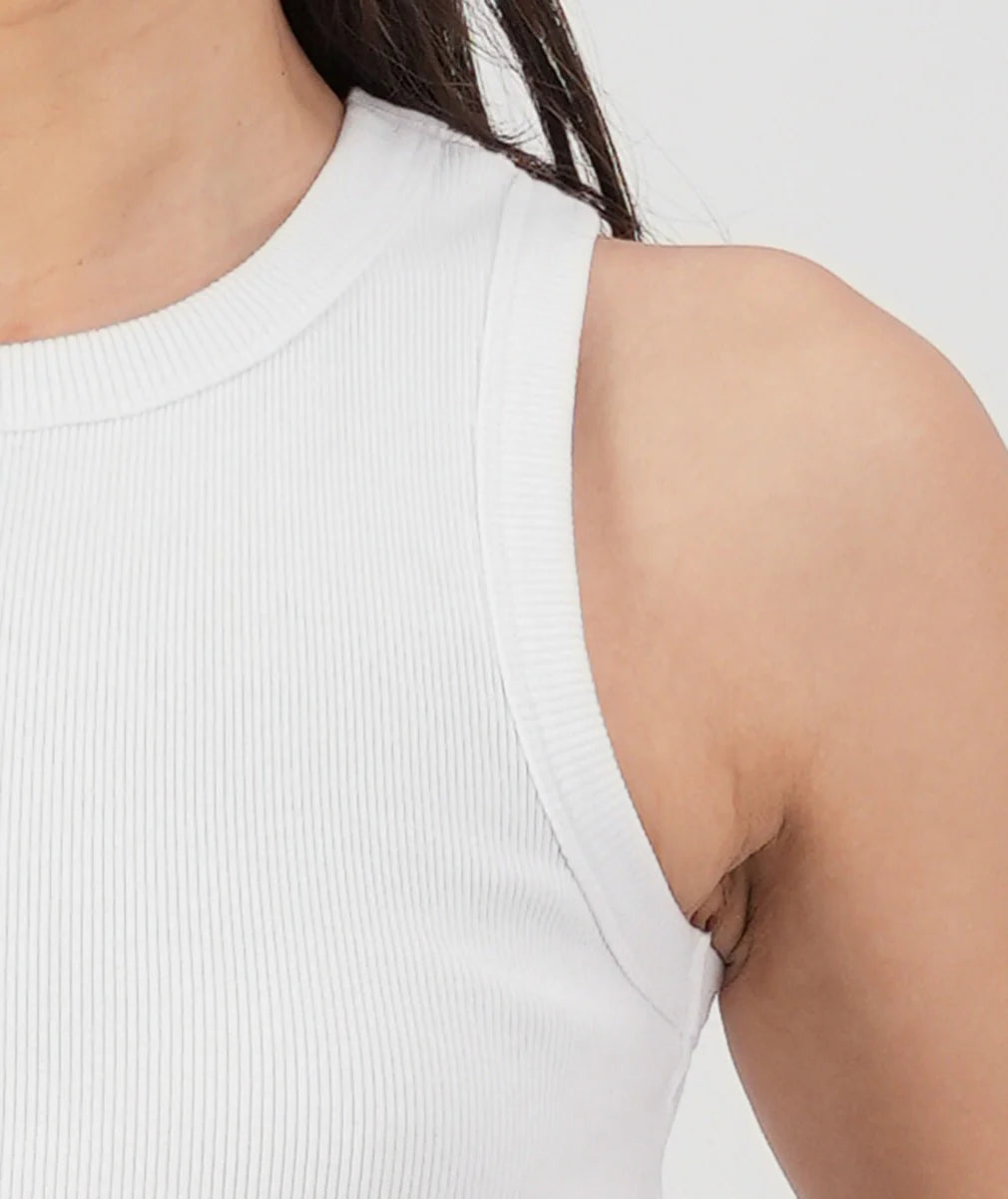White sleeveless top worn by a person on a plain background