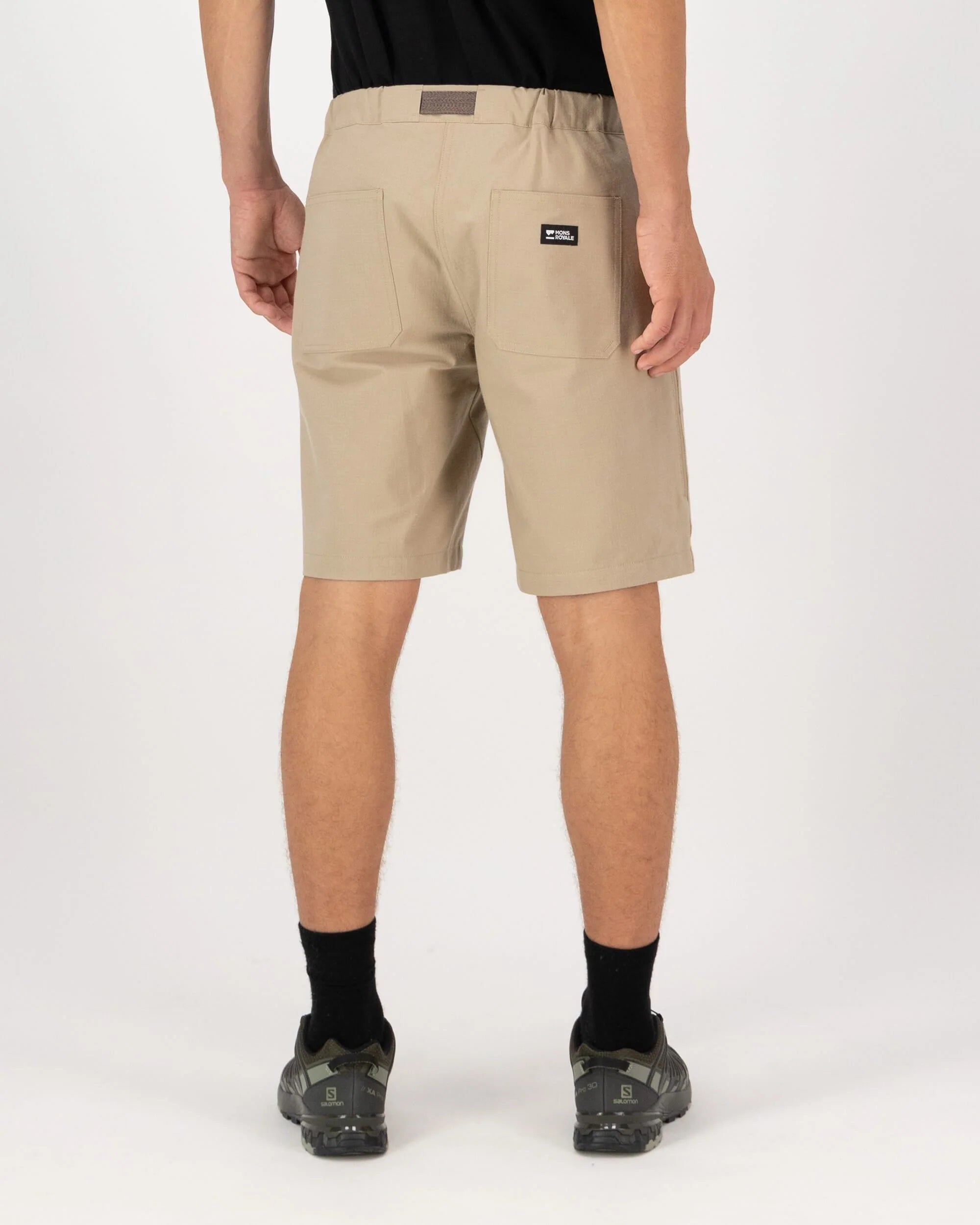 Beige shorts worn by a person on a white background