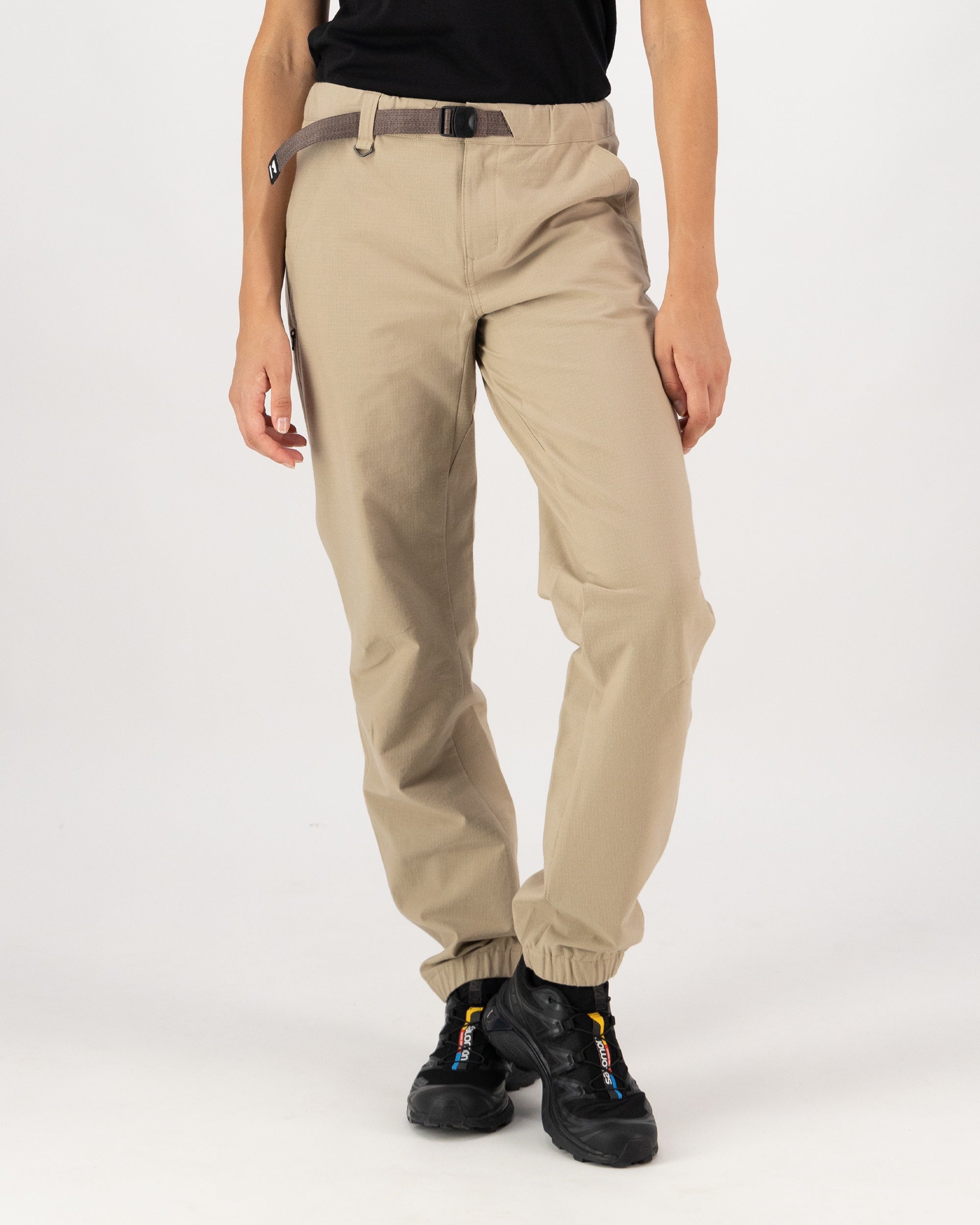Beige pants worn by a person on a white background