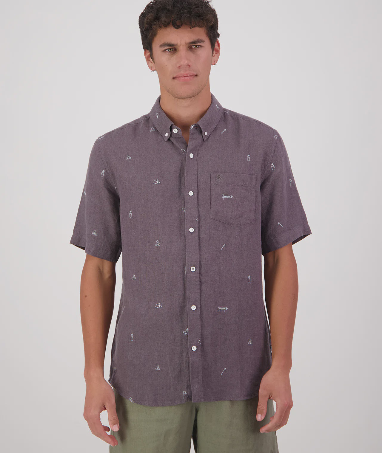 Man wearing a patterned short-sleeve shirt on a plain background