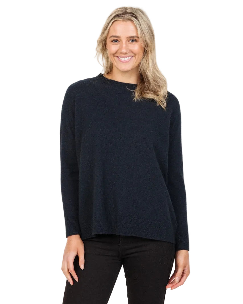 Woman wearing a black long-sleeve top and black pants on a white background