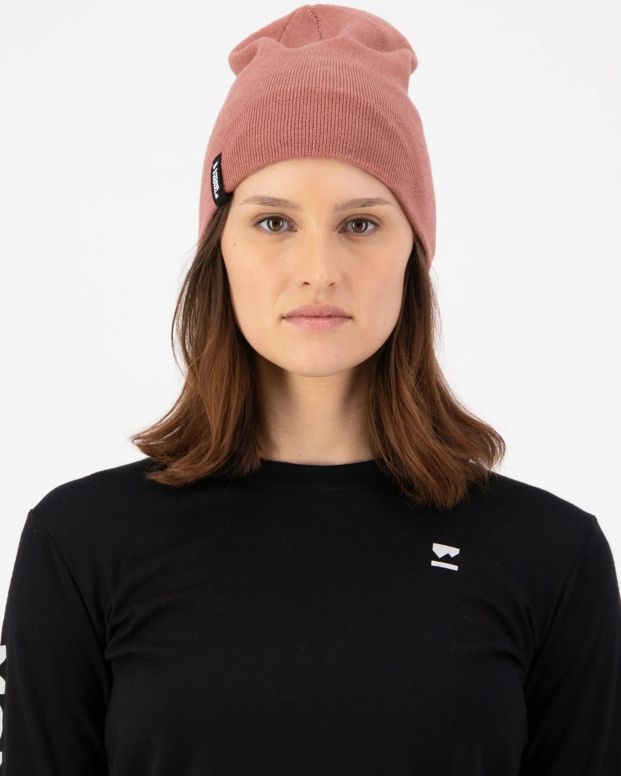 Person wearing a pink beanie and black shirt with a logo on a white background