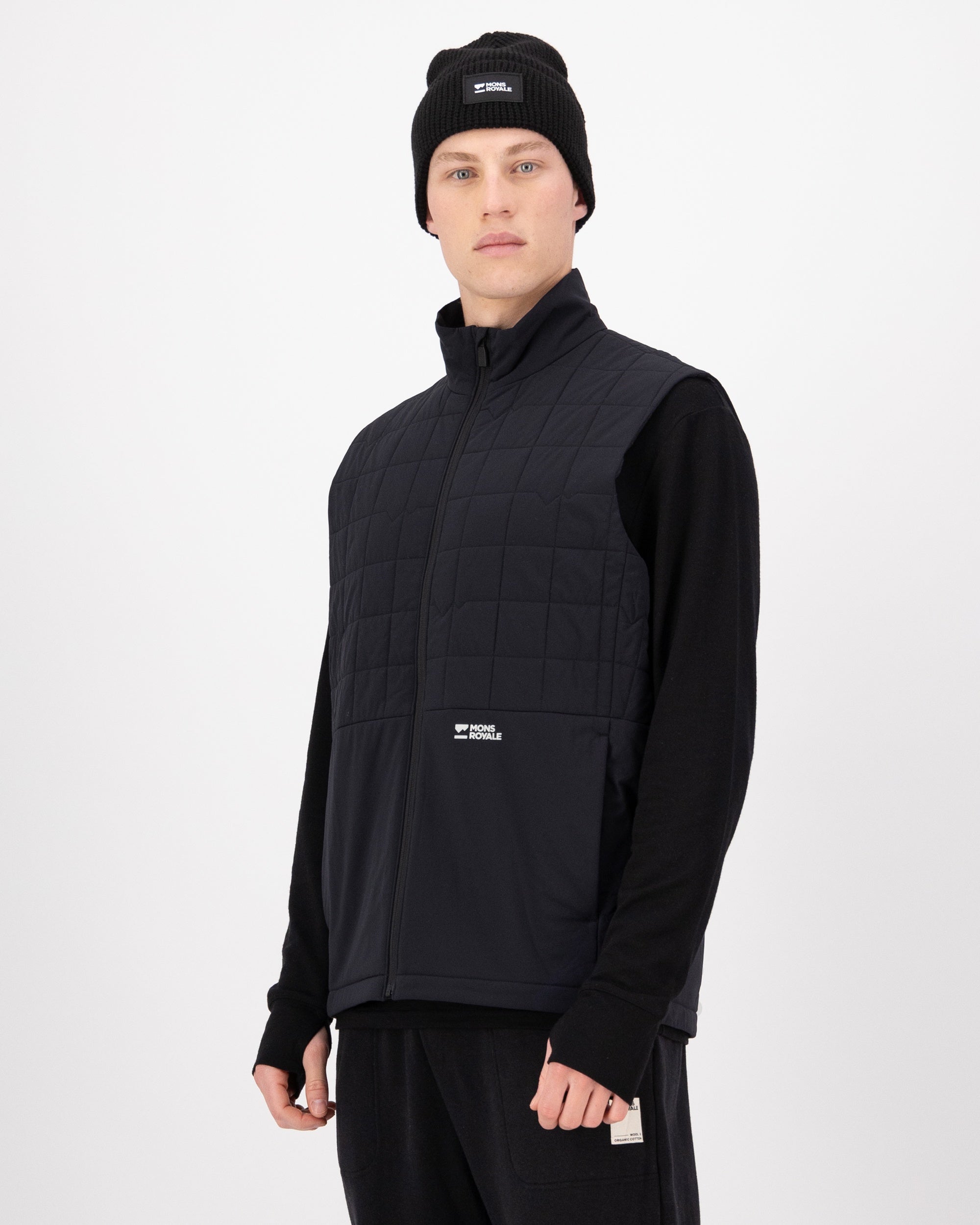 Person wearing a black vest and beanie on a white background