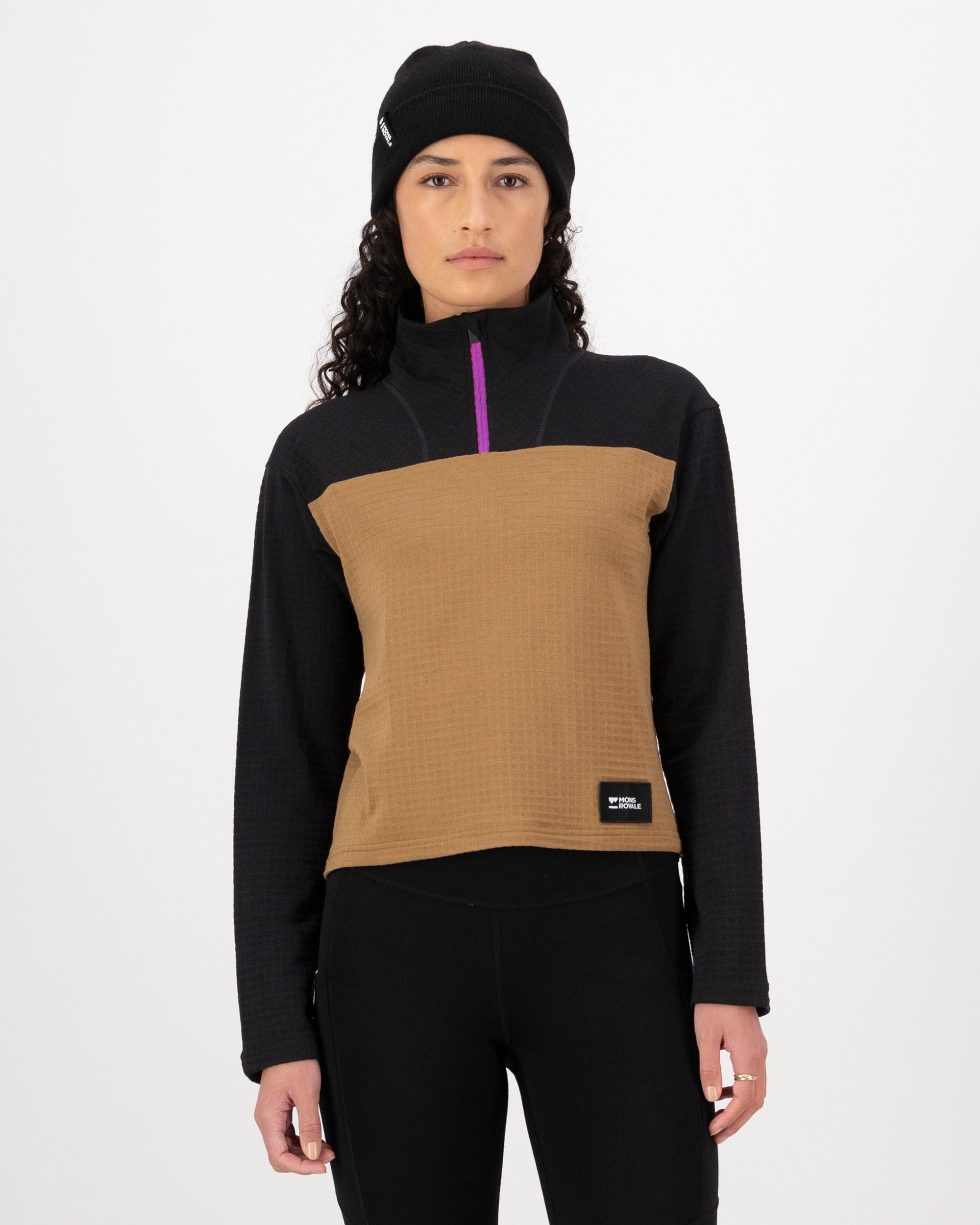 Person wearing a black and brown pullover with a visible brand logo on a white background