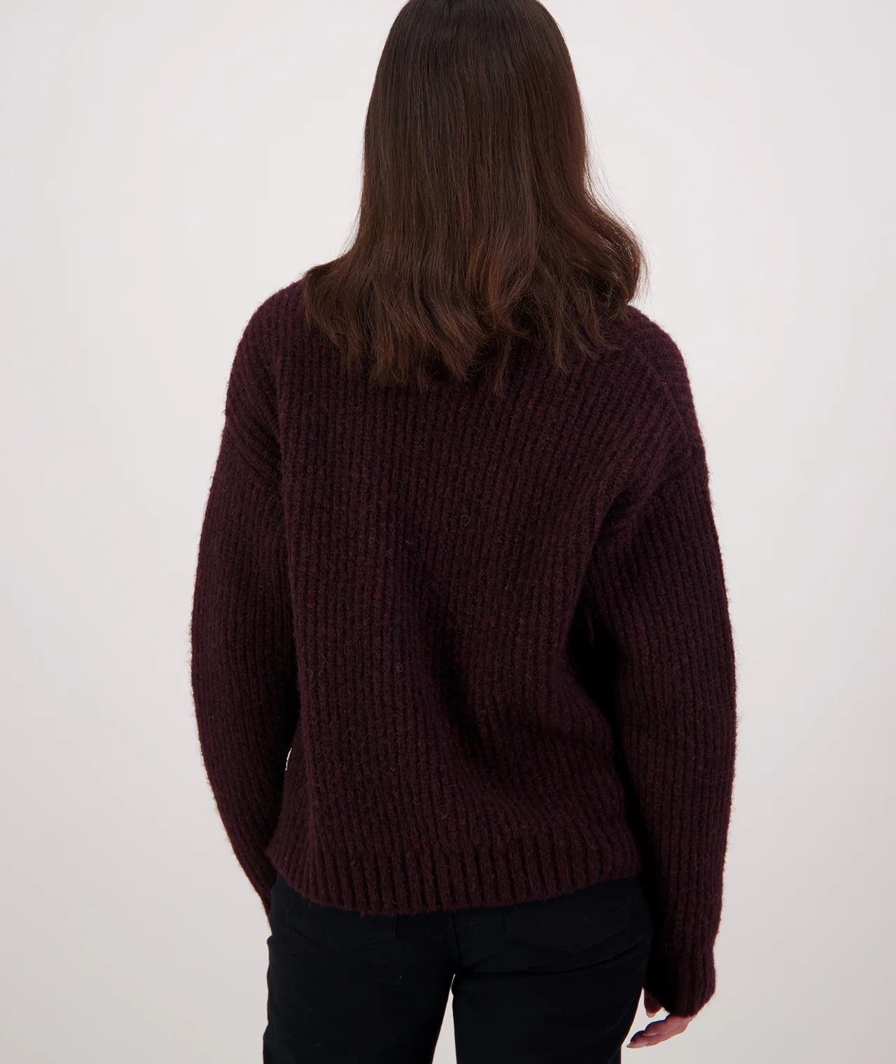 Person wearing a shiraz coloured cardigan on a white background