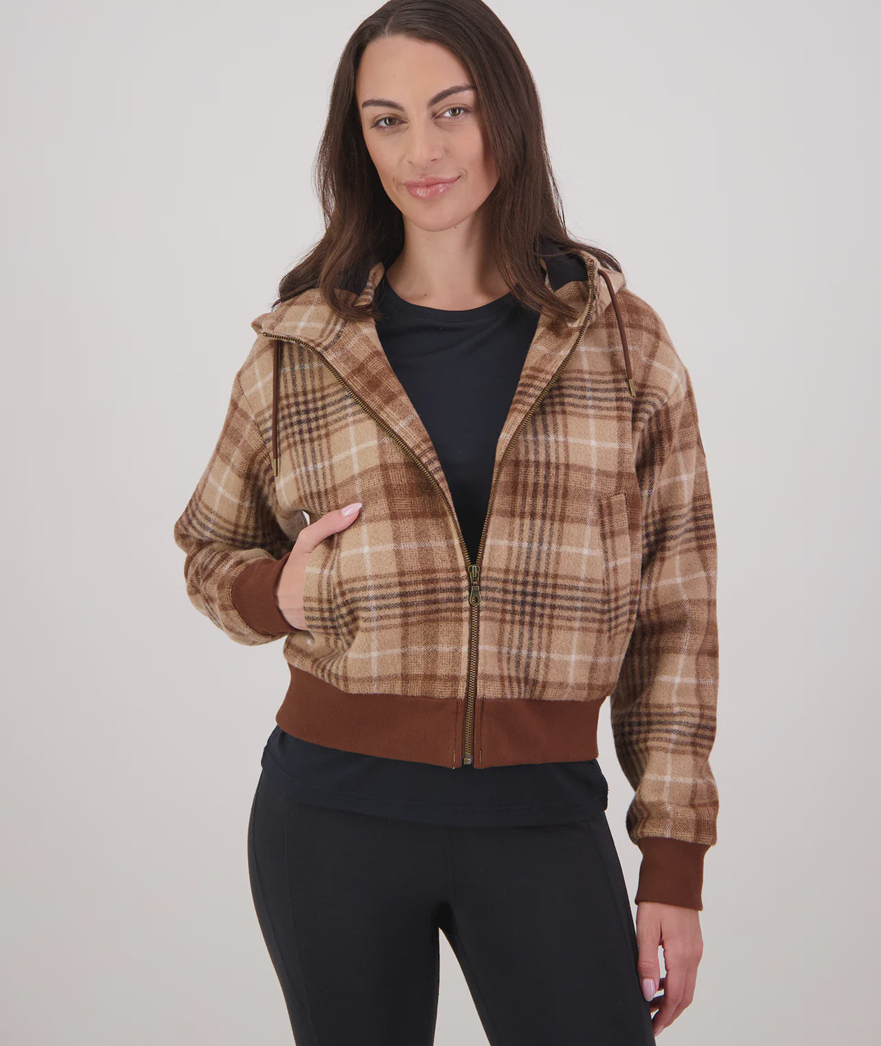 Woman wearing a plaid jacket with a neutral background