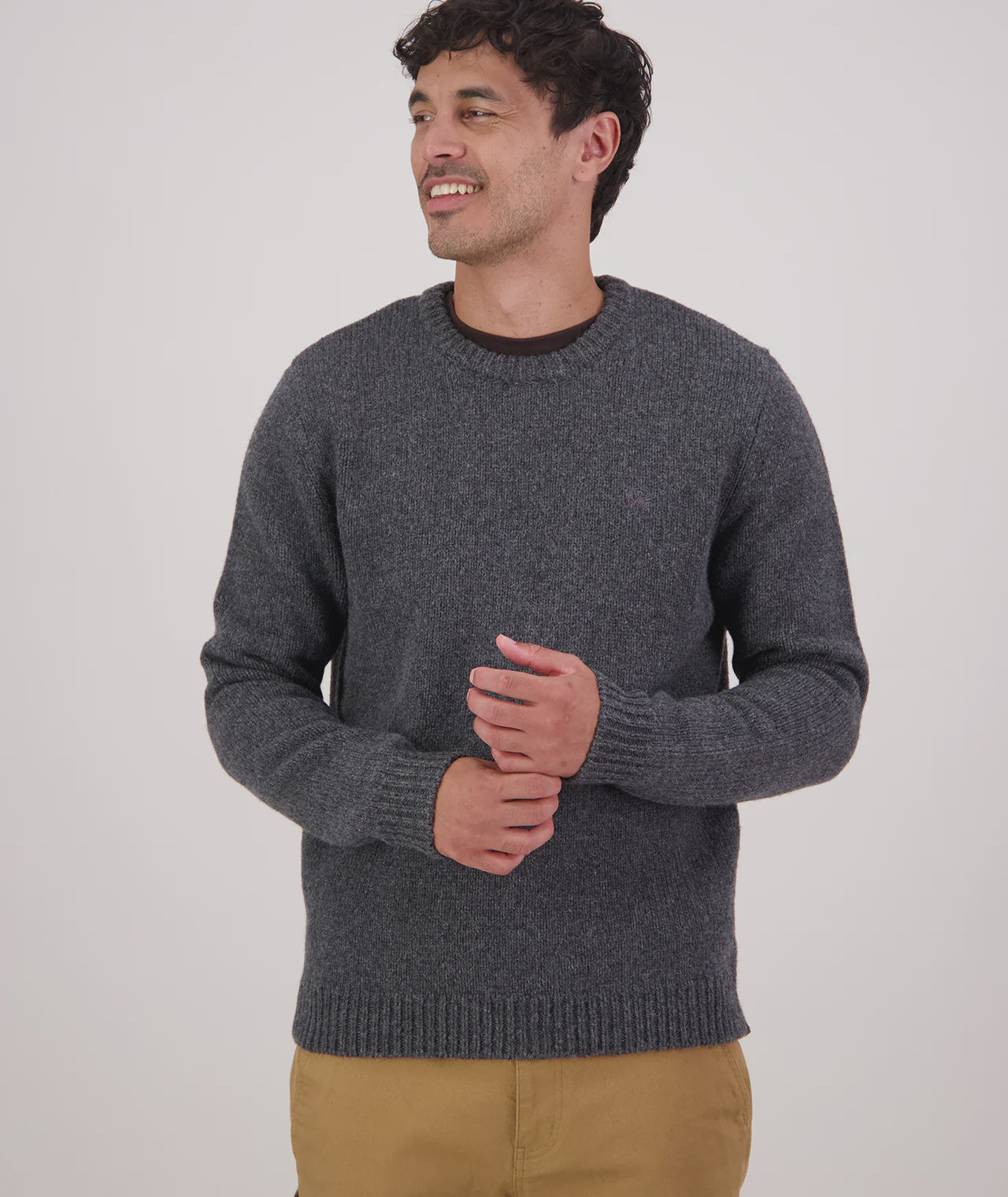 Man wearing a gray sweater against a white background