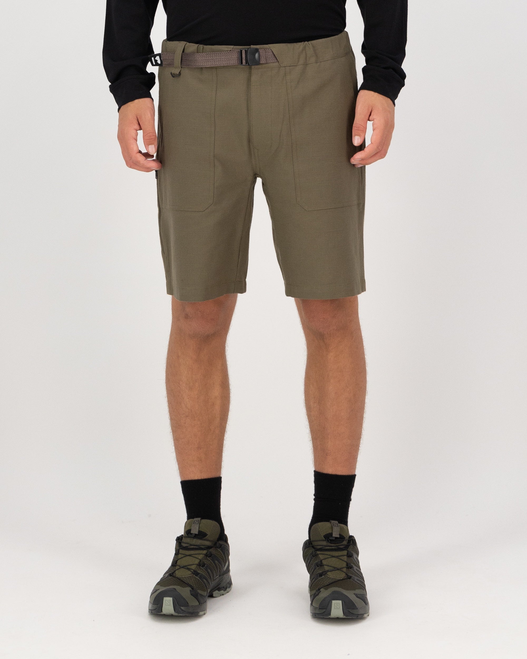 Person wearing olive green shorts on a white background