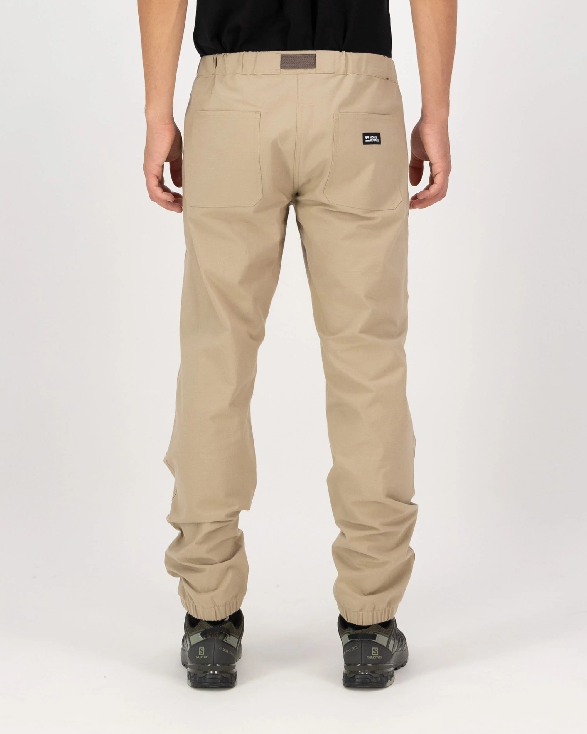 Beige pants worn by a person on a white background