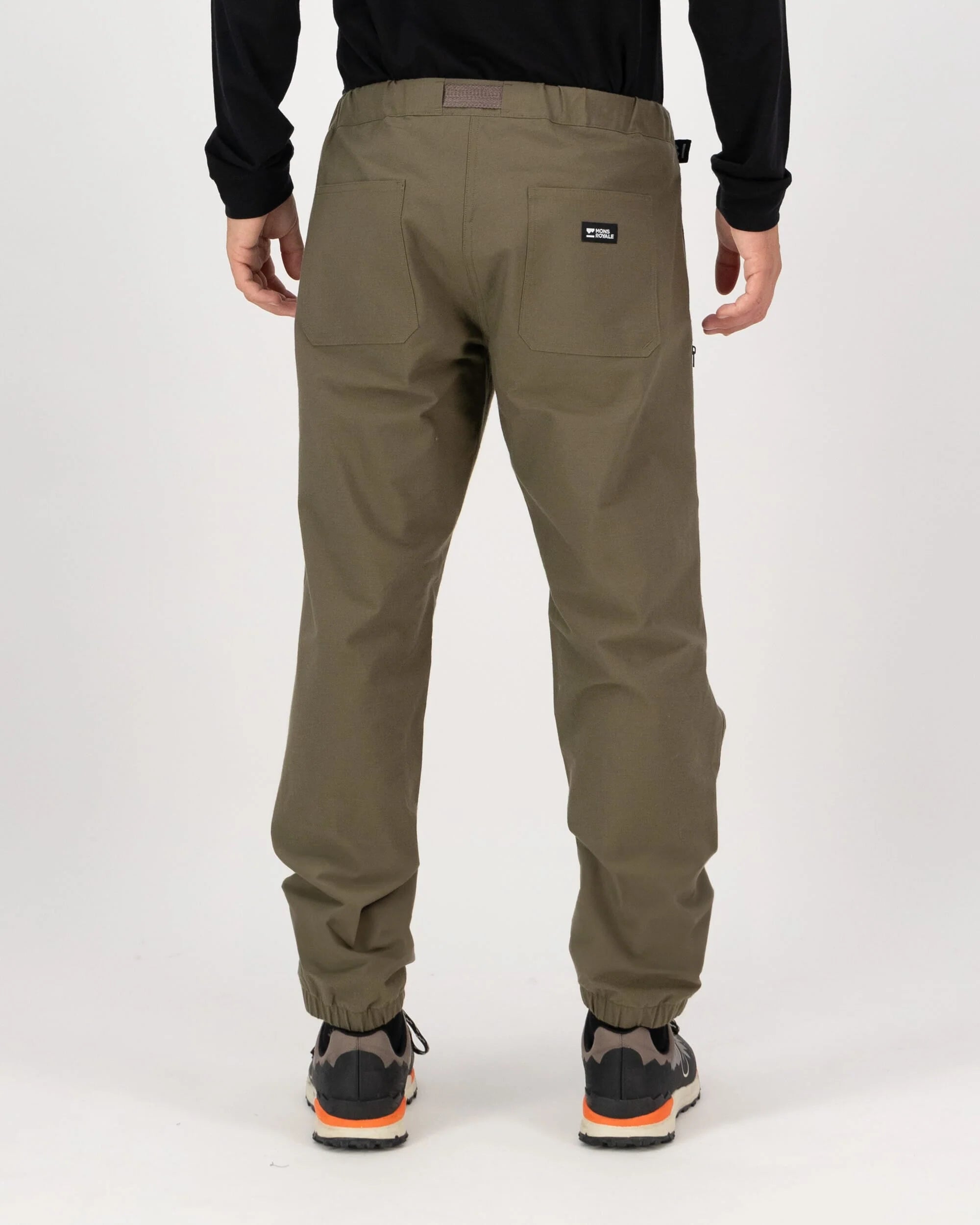 Person wearing khaki pants with a visible brand logo on a white background