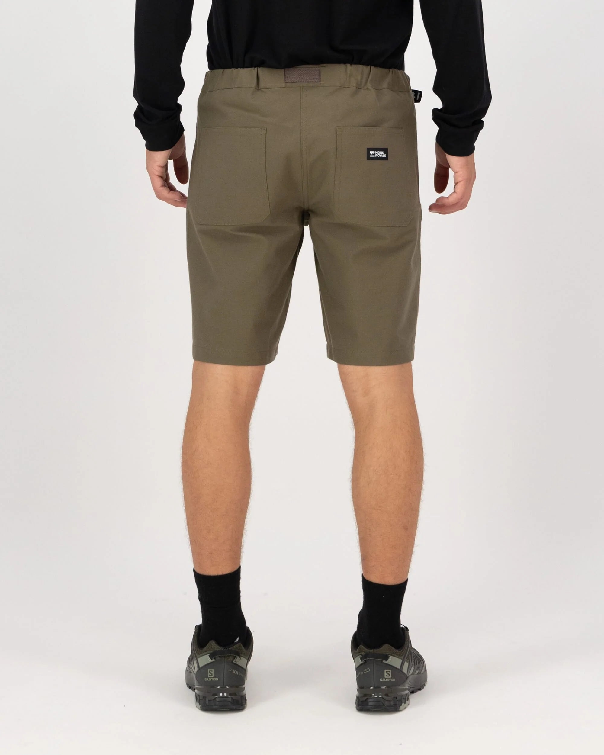 Person wearing olive green shorts on a white background