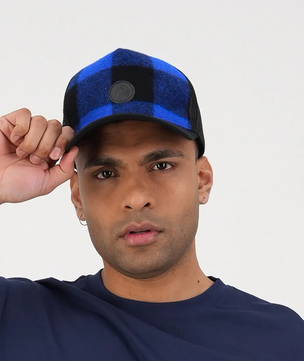 Man wearing a blue and black cap against a plain background