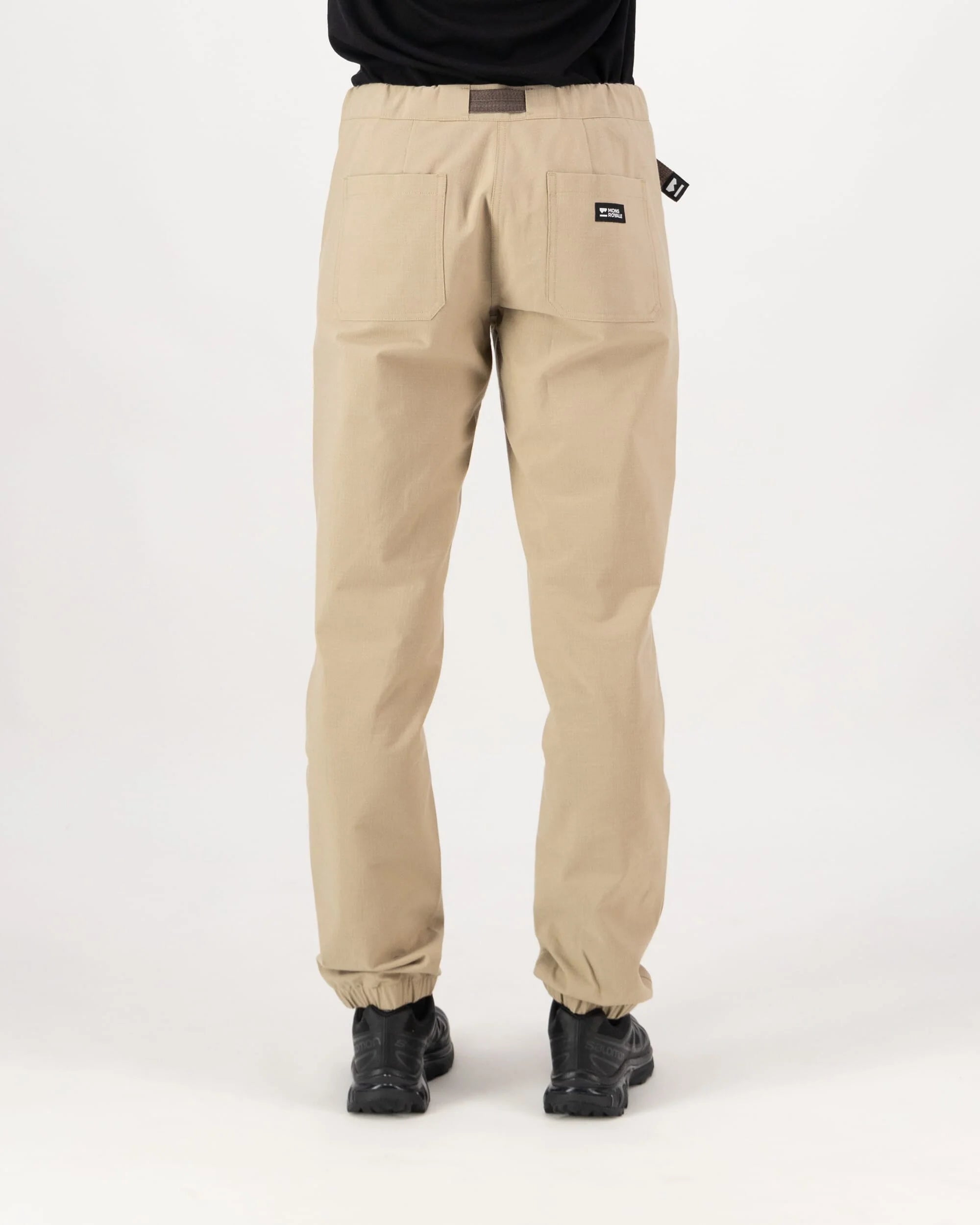 Beige pants worn by a person on a white background