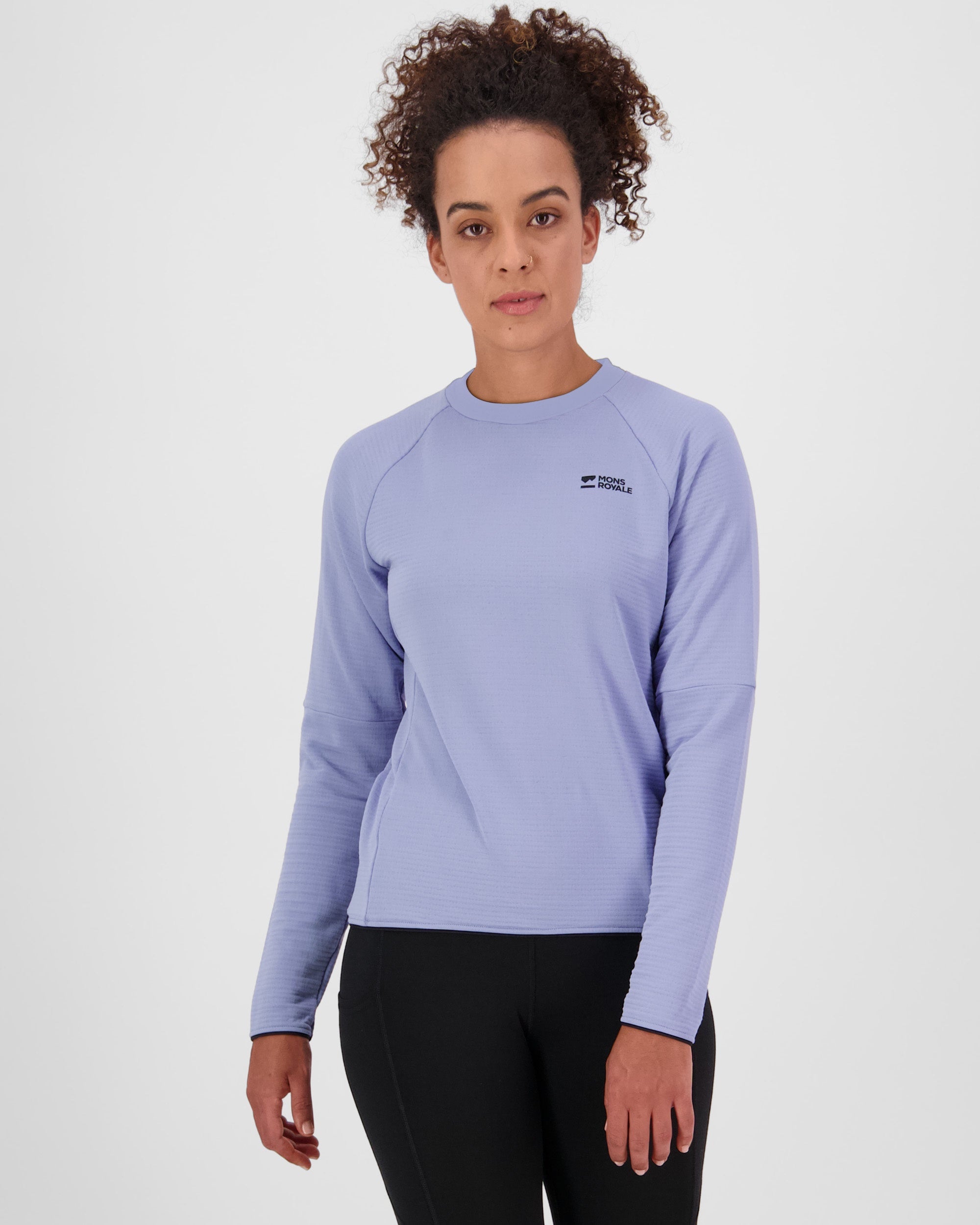 Woman wearing a light purple long-sleeve shirt with a brand logo on a white background